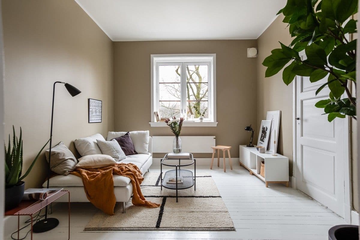 Stue med lyse møbler og oransje pledd, Uelands gate 65